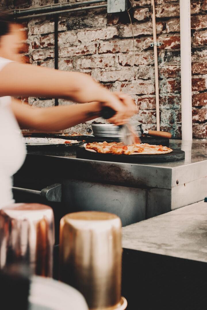 Woman making pizza in a restaurant kitchen
